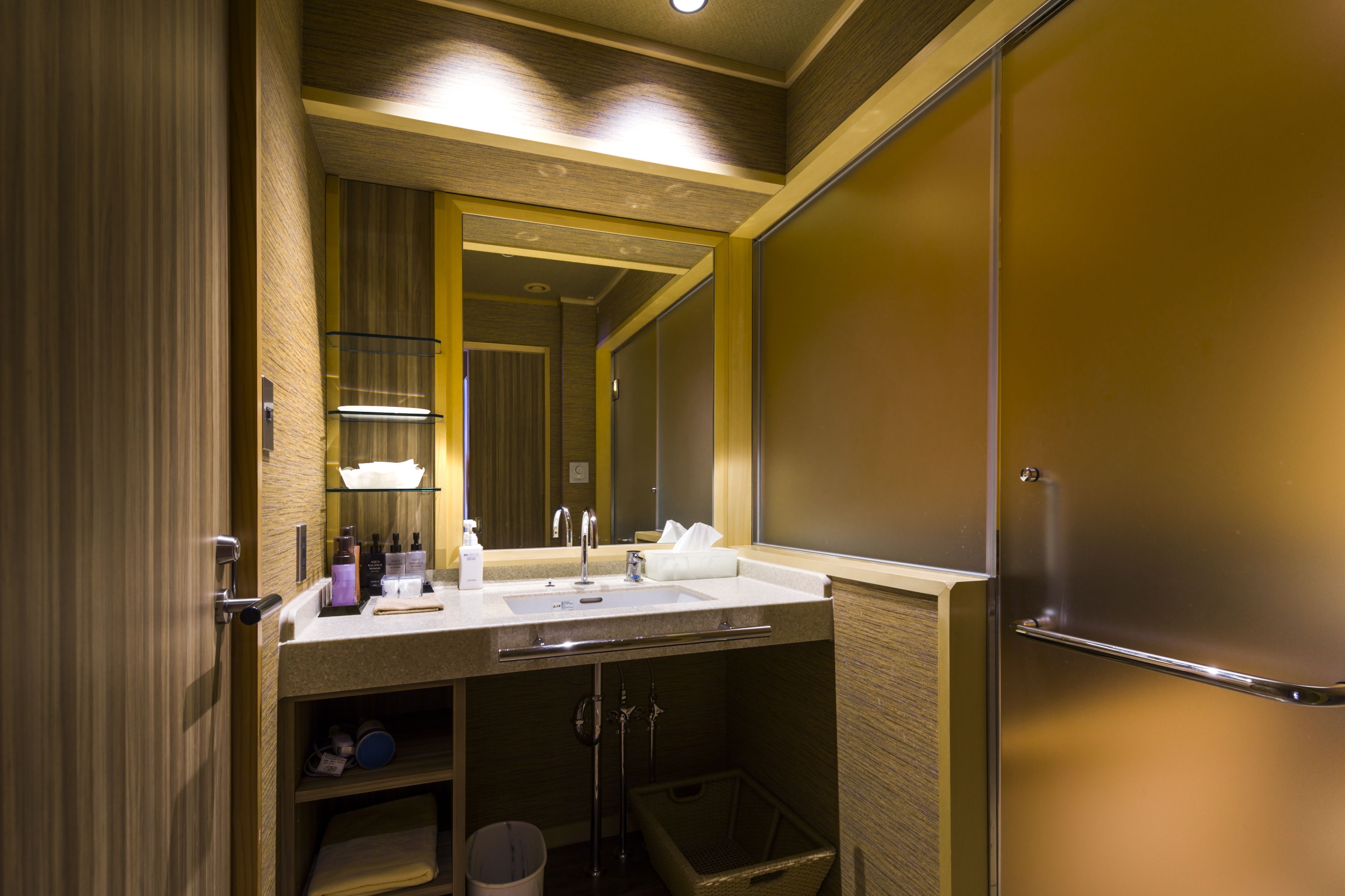 A modern bathroom with a sink, mirror, and towel rack.