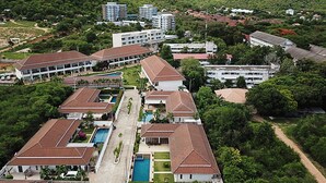 A resort with multiple buildings, a central swimming pool, and lush greenery surrounding the property. - Thiva Pool Villa Hua Hin (Hua Hin)