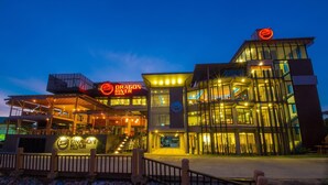 A modern building with a prominent Dragon River Avenue sign, featuring a glass facade and multiple levels. - Dragon River Avenue Hotel (Phitsanulok)