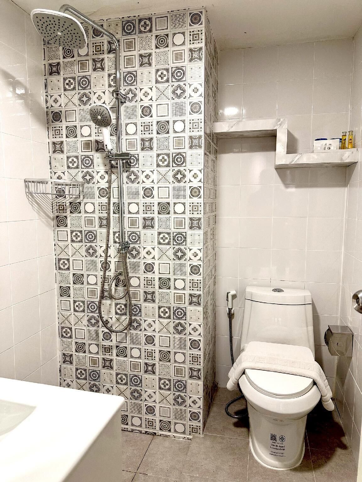 A bathroom with a shower, toilet, and a sink.