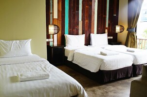 Habitación de hotel con dos camas, paneles de madera en la pared y dos lámparas de noche.