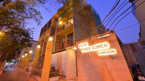 A multi-story building with balconies and a sign reading "Villa Phra Sumen Bangkok".