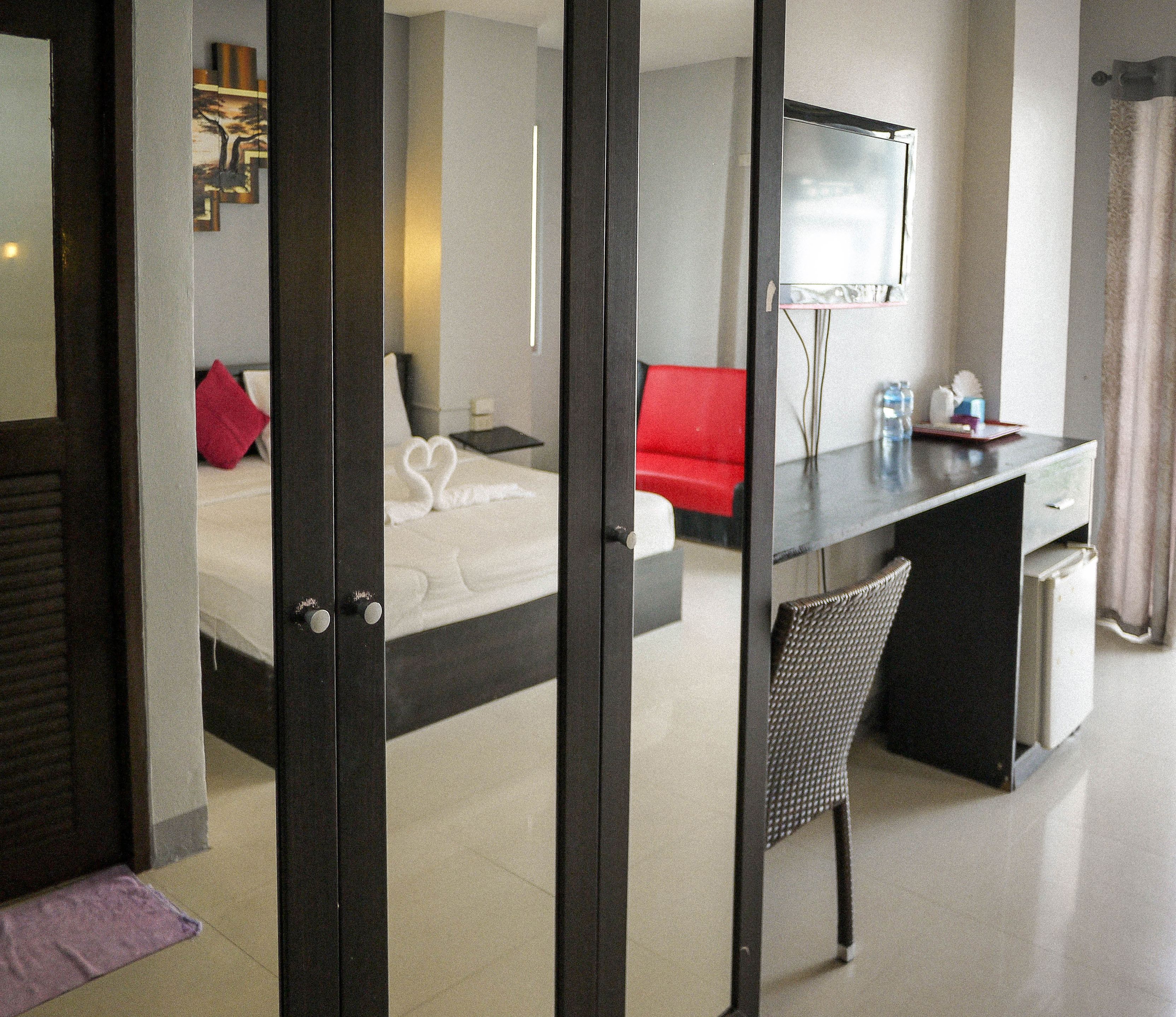 Une chambre d’hôtel comprenant un lit, un bureau, une chaise, une télévision et une salle de bain.