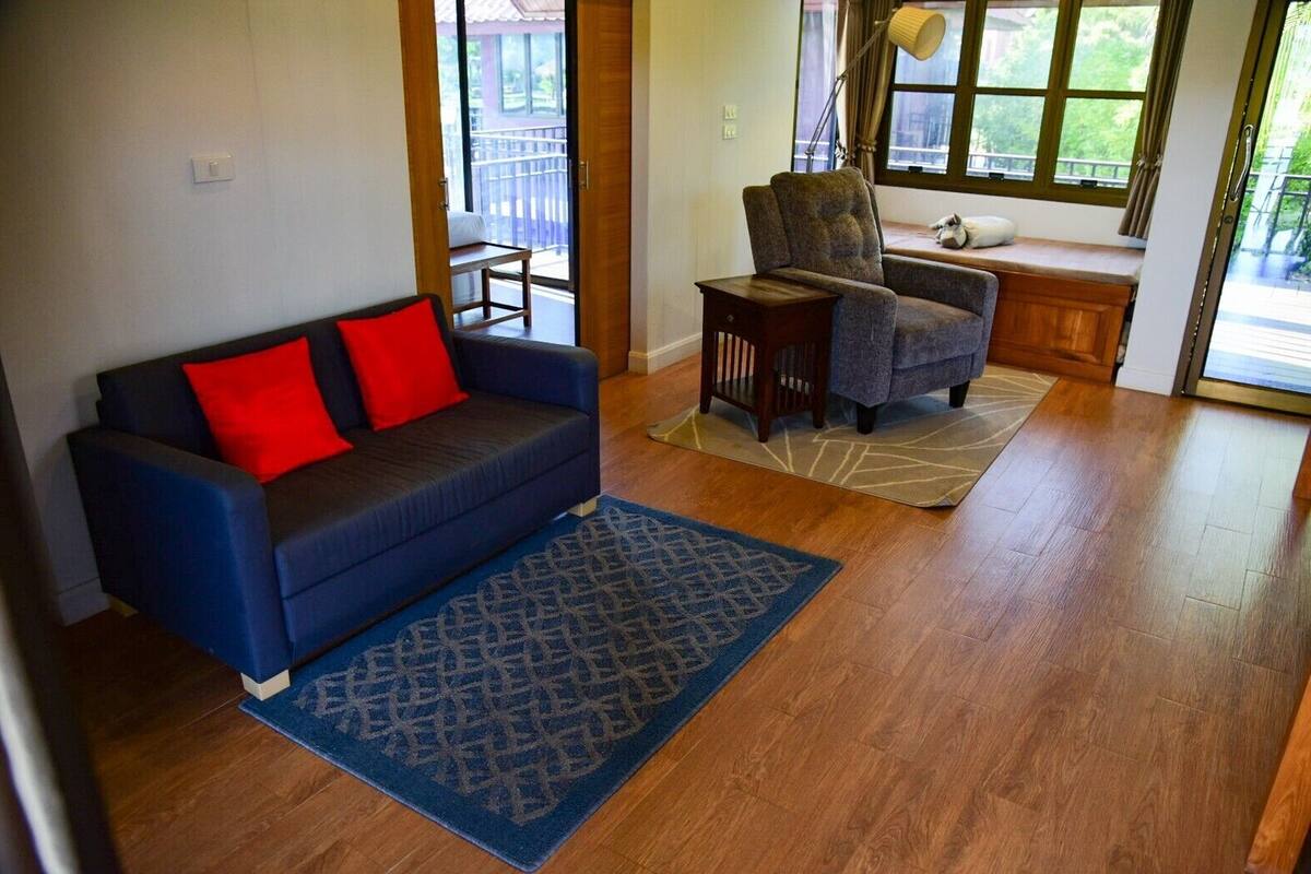 A living room with a blue sofa, a wooden coffee table, and a patterned rug.