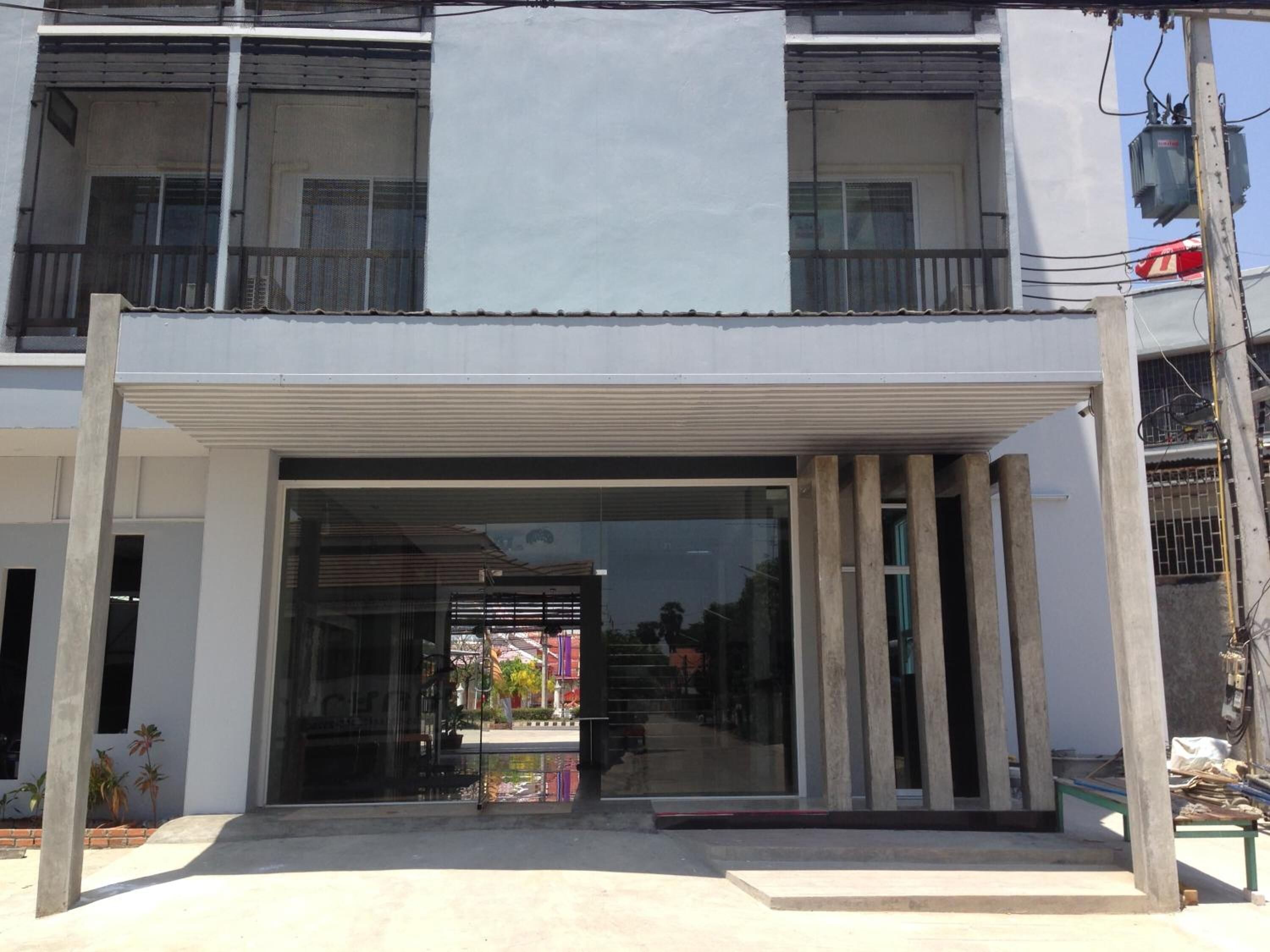 A modern building with a large glass entrance and a covered area.