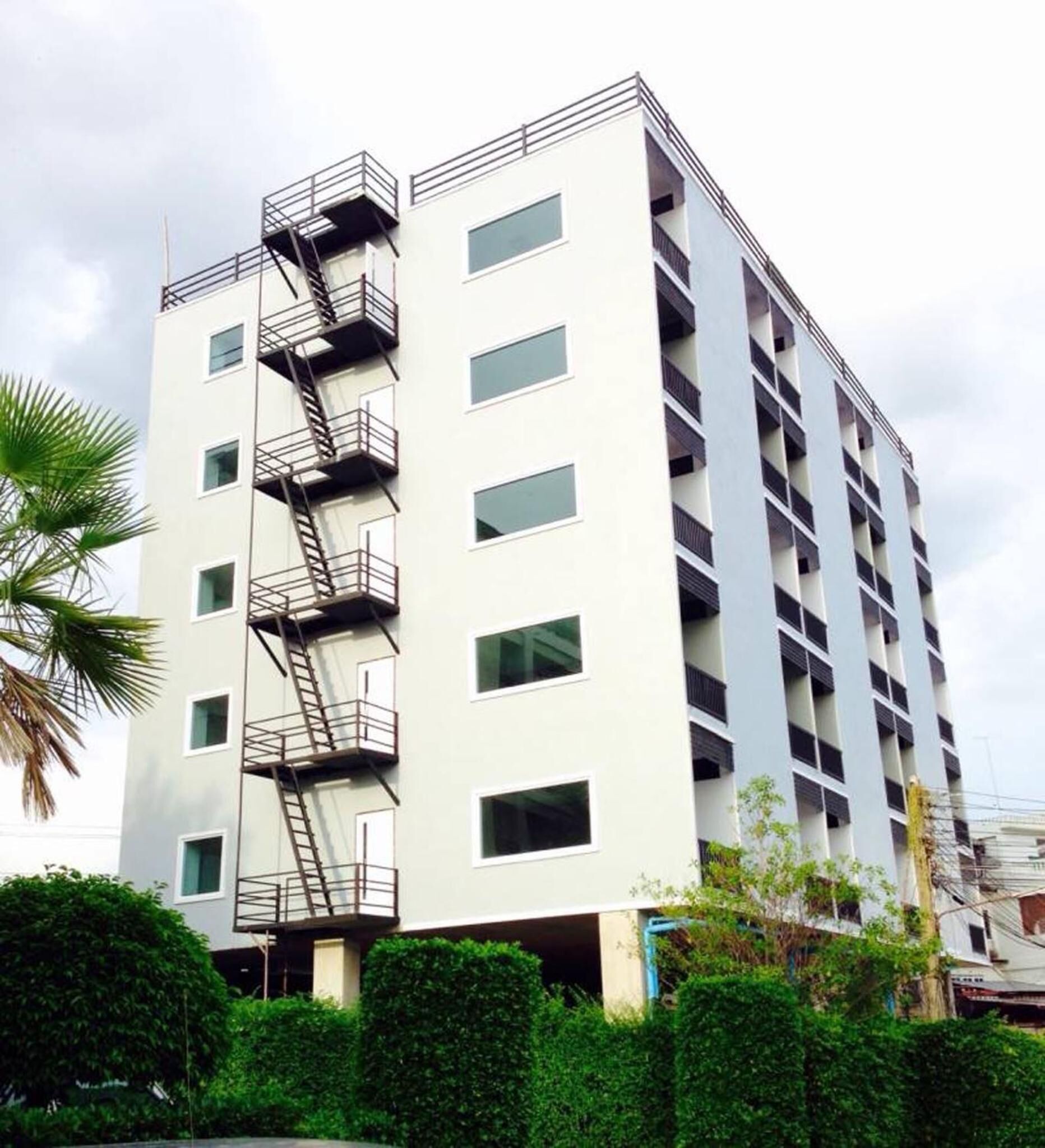 Un edificio de varios pisos con un vestíbulo central y varios balcones.