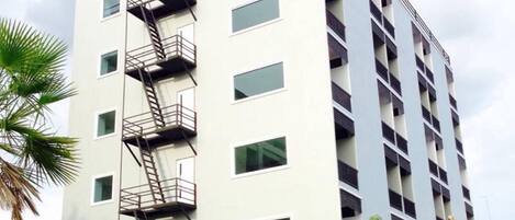 Un edificio de varios pisos con un vestíbulo central y varios balcones.