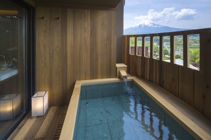 A wooden deck with a hot tub, a glass door, and a view of a mountain. - Fujisan Onsen Bessho SASA (Fujiyoshida)
