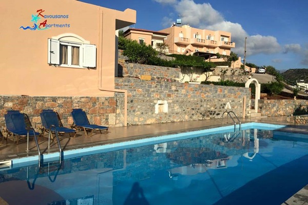 Una piscina al aire libre, sombrillas, sillones reclinables de piscina