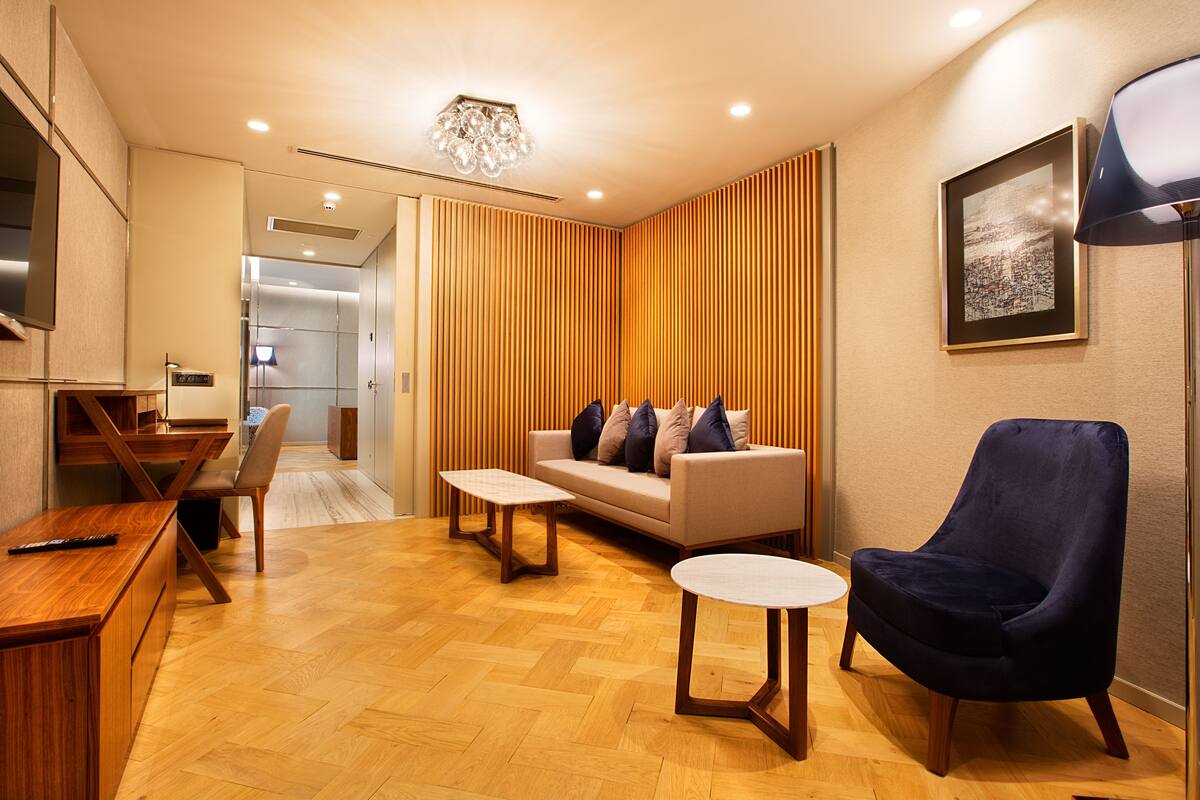 Un salon moderne avec un canapé, des fauteuils, une table basse et un téléviseur.
