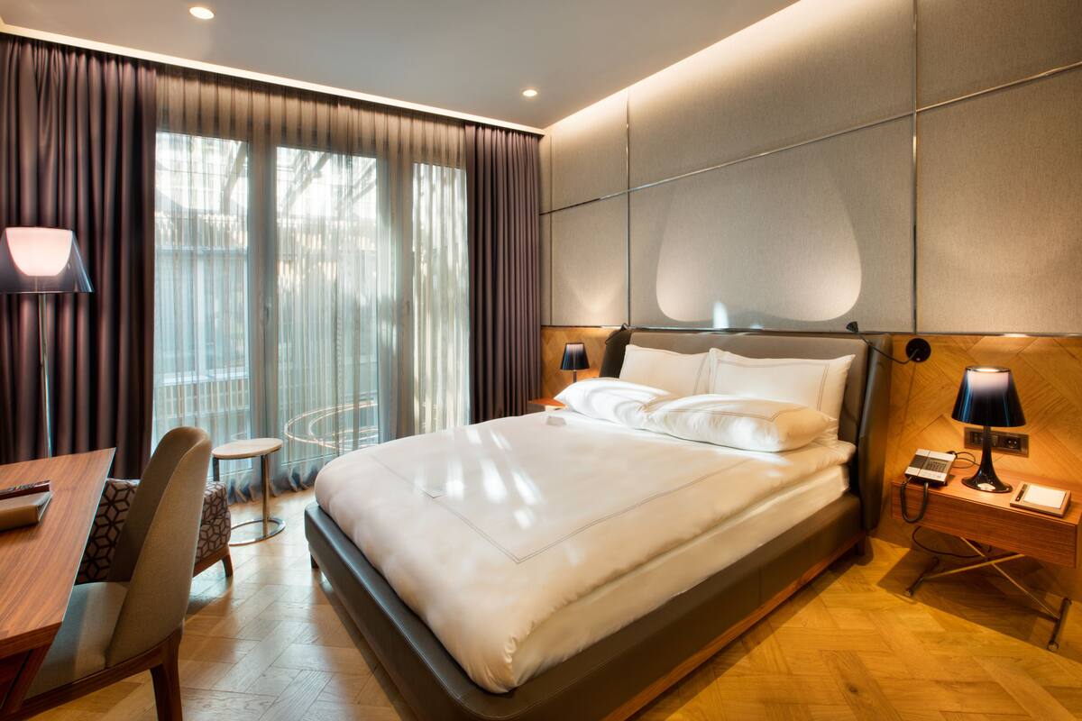 Une chambre d’hôtel moderne, dotée d’un grand lit, d’un bureau et d’une chaise.