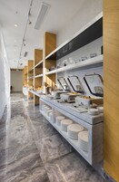 Montaje de bufé con varias estaciones de servicio, piso de mármol y detalles de madera.