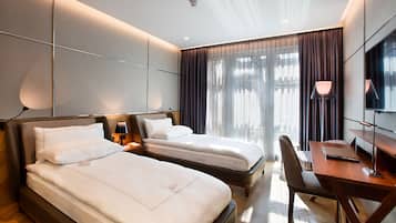 Ein Hotelzimmer mit zwei Betten, einem Schreibtisch und einem Stuhl.