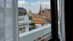 A view of traditional Thai architecture through a window with curtains. - Chetuphon Gate (Bangkok)