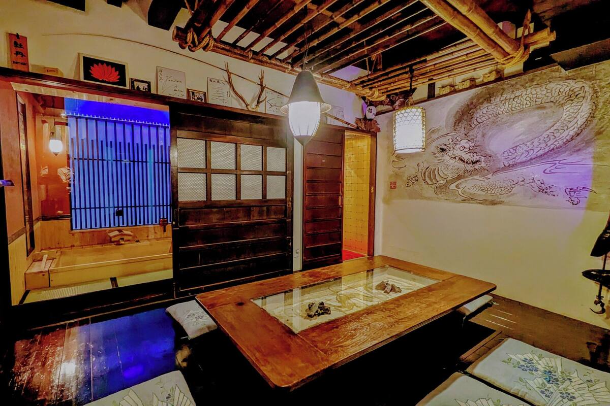 A traditional Japanese room with tatami flooring, a shoji screen door, a hanging lantern, and a dragon mural.