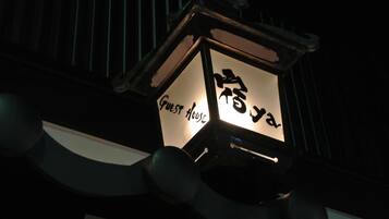 Lanterna com caracteres japoneses e a inscrição "Guest House".