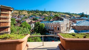 Un balcón con vistas a un pueblo, con edificios y una colina al fondo.