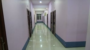 Passadís llarg i estret amb portes a banda i banda, que condueix a una habitació al final.