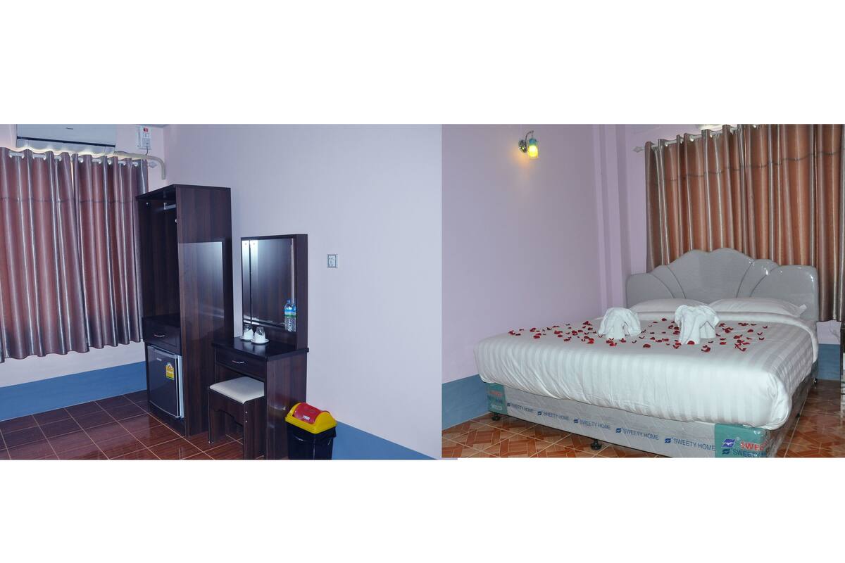 A hotel room with a bed, a desk, a television, and a trash bin.