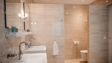 Un baño moderno con dos lavamanos, un espejo y un inodoro.