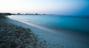 Di pantai, kursi berjemur, payung pantai, dan handuk pantai