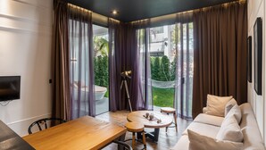 Una sala moderna con una mesa de comedor de madera, un sofá y una hamaca.