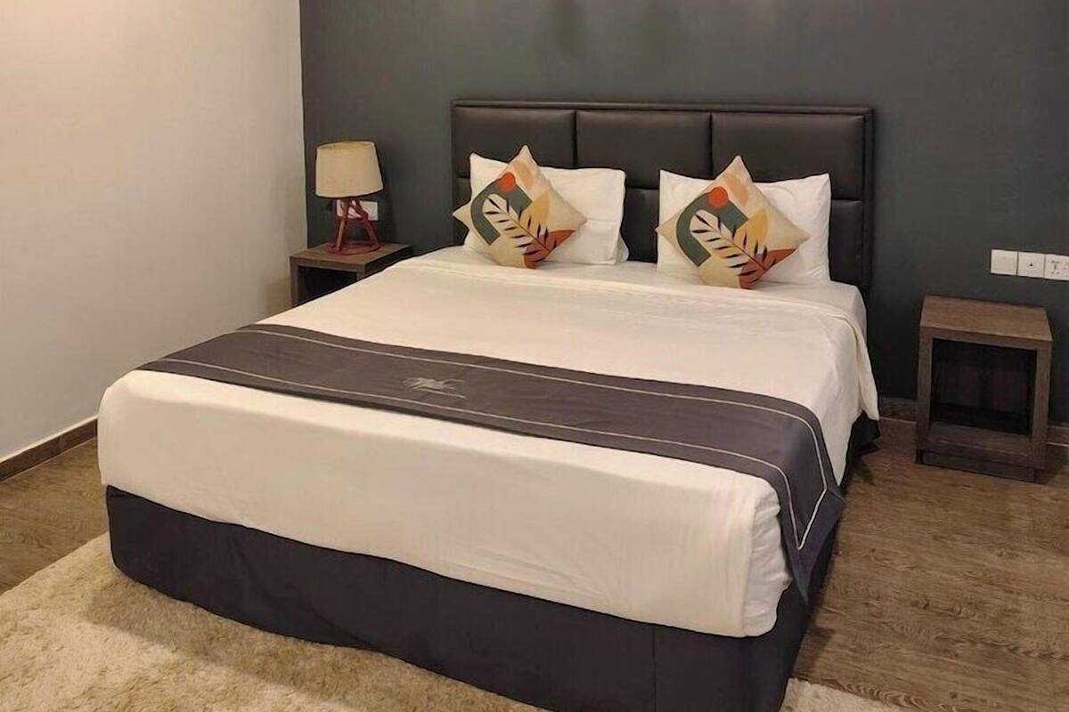 Un dormitorio moderno con una cama grande, dos mesitas de noche y un aparador.