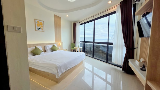 Een moderne hotelkamer met een groot bed, een televisie en een balkon met uitzicht.