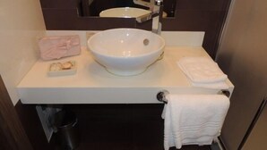 A bathroom with a white sink, a mirror, a towel rack, and a trash bin. - Albergo Ristorante Delfino (Novara)
