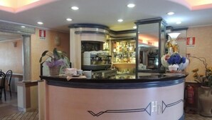 A hotel reception area with a counter, a coffee machine, and a display of bottled water. - Albergo Ristorante Delfino (Novara)