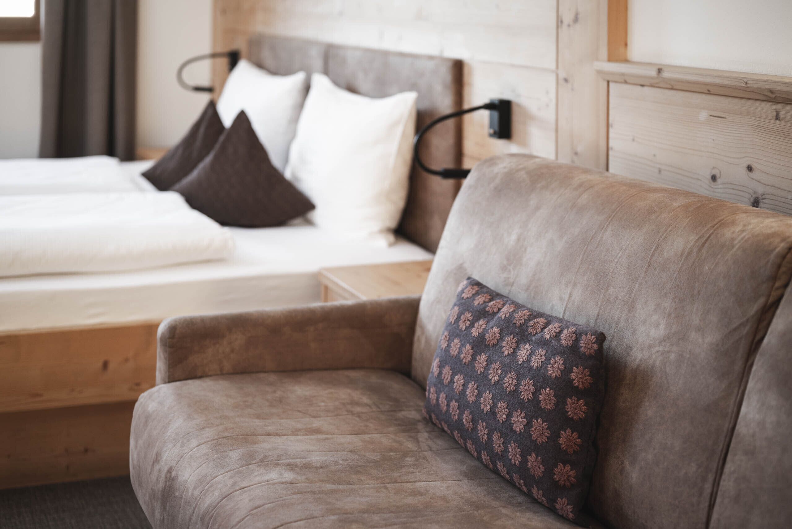 A bedroom with a bed, a sofa, and a nightstand.