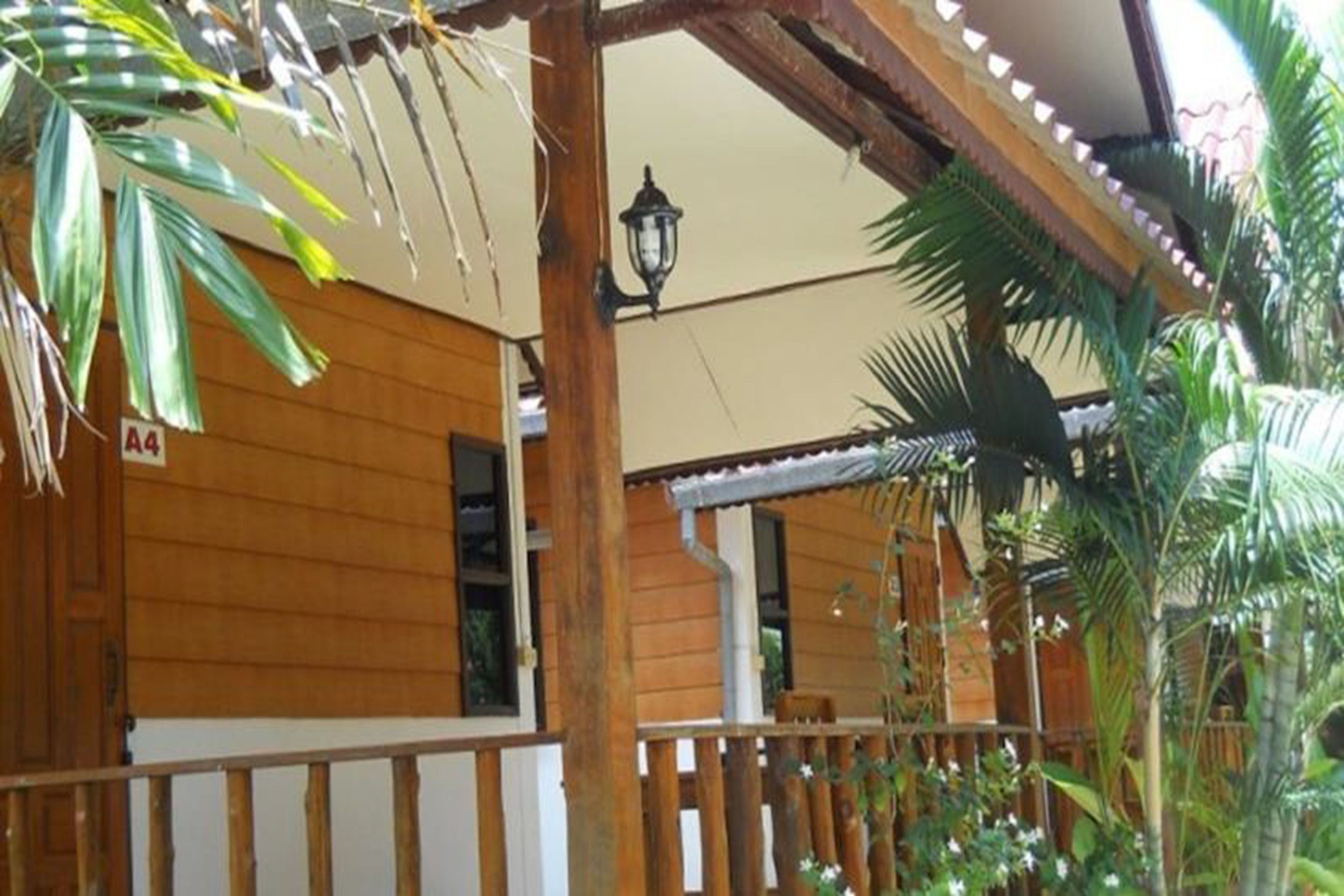 A wooden building with a balcony, a sign indicating room number A4, and a lantern.