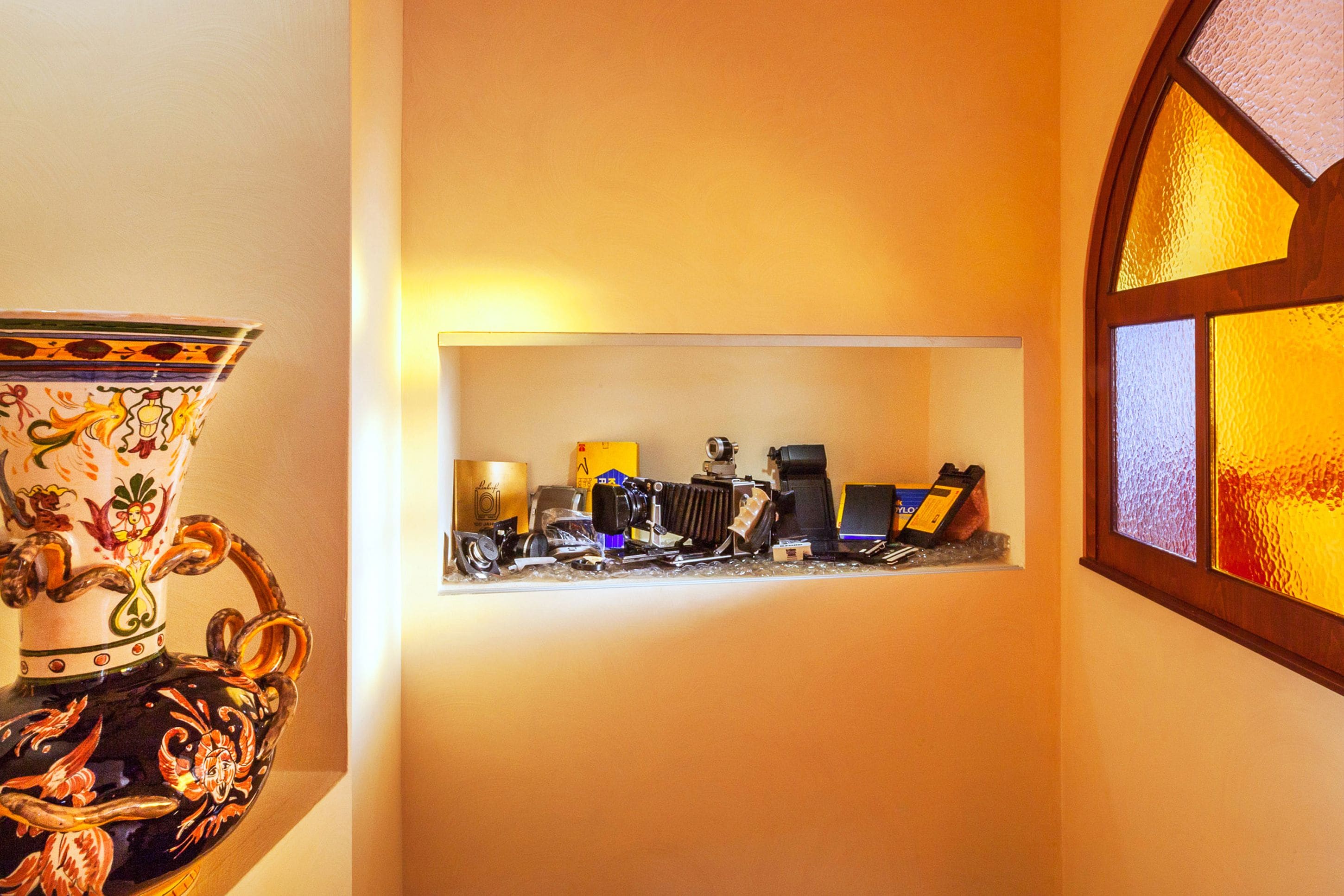 Une étagère avec divers appareils électroniques et un vase décoratif.