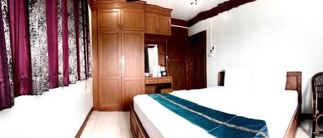 Une chambre à coucher avec un lit, une armoire en bois et une chaise.