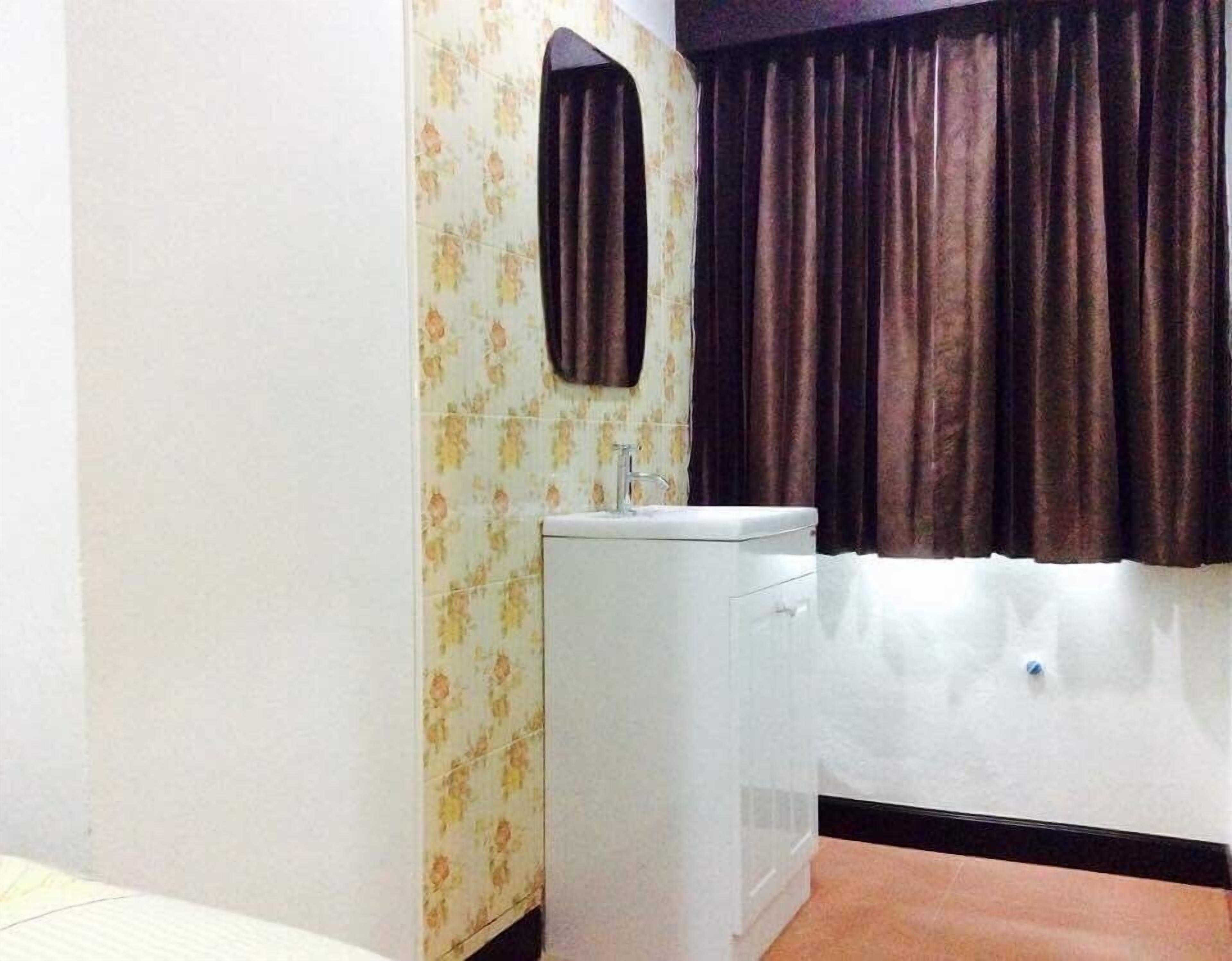 Een badkamer met een wastafel, spiegel en bad.