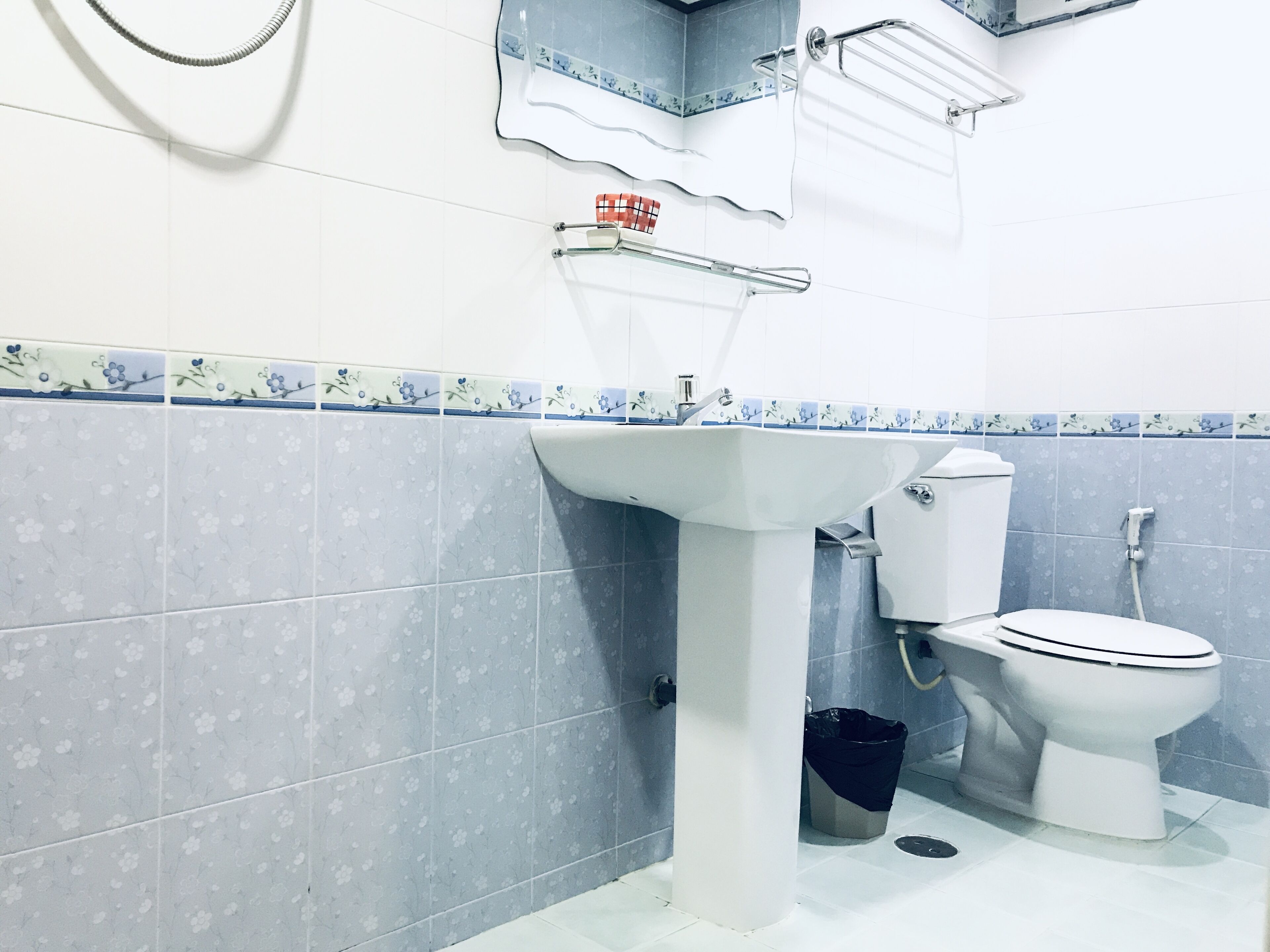 Un baño con lavamanos blanco, inodoro y zona de ducha.