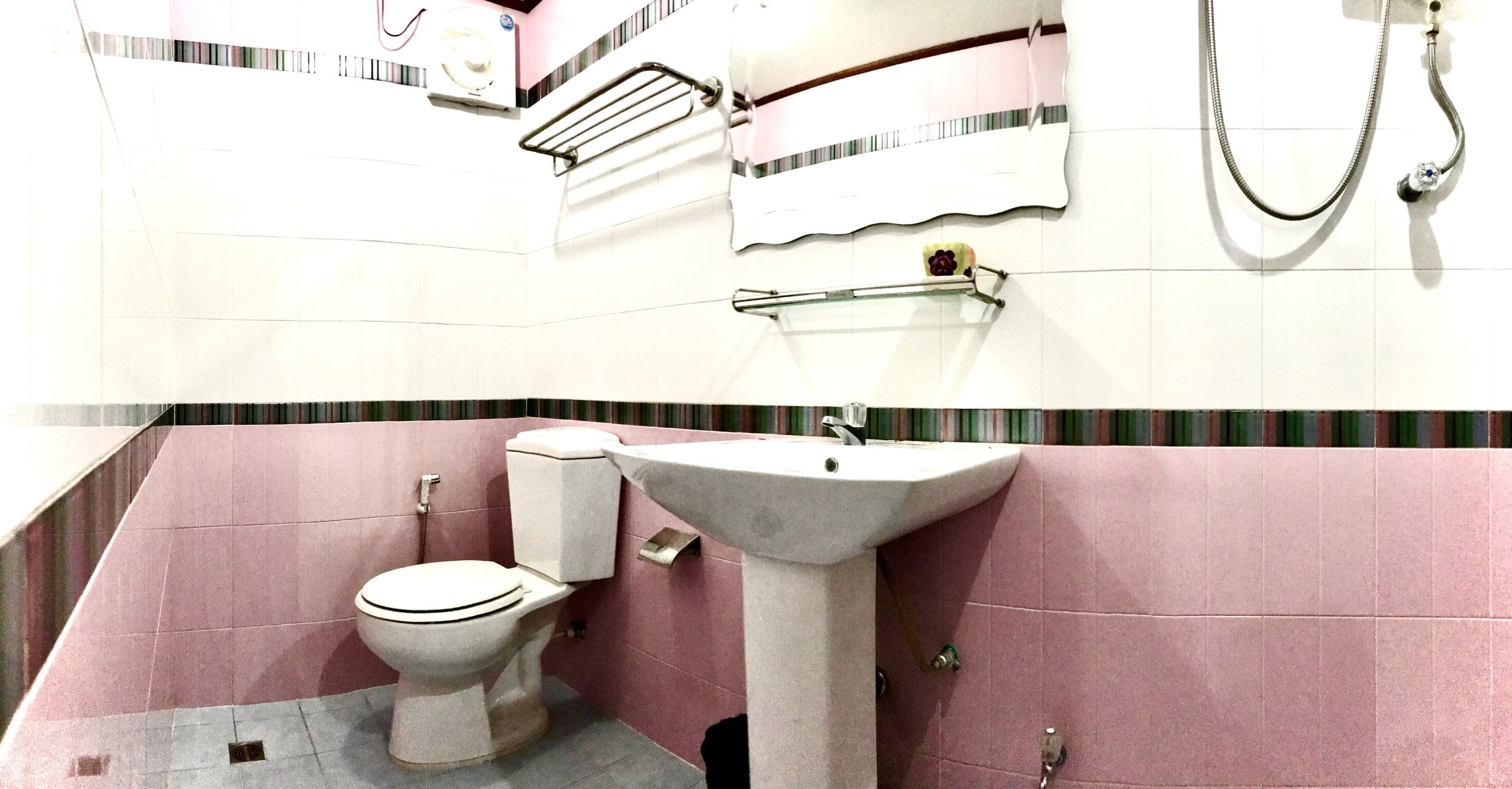 A bathroom with a toilet, sink, and towel rack.