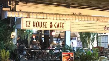 A building with a sign reading "EZ HOUSE & CAFE".