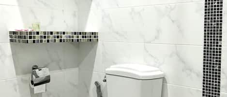 Casa de banho com sanita, chuveiro e parede revestida a azulejos.