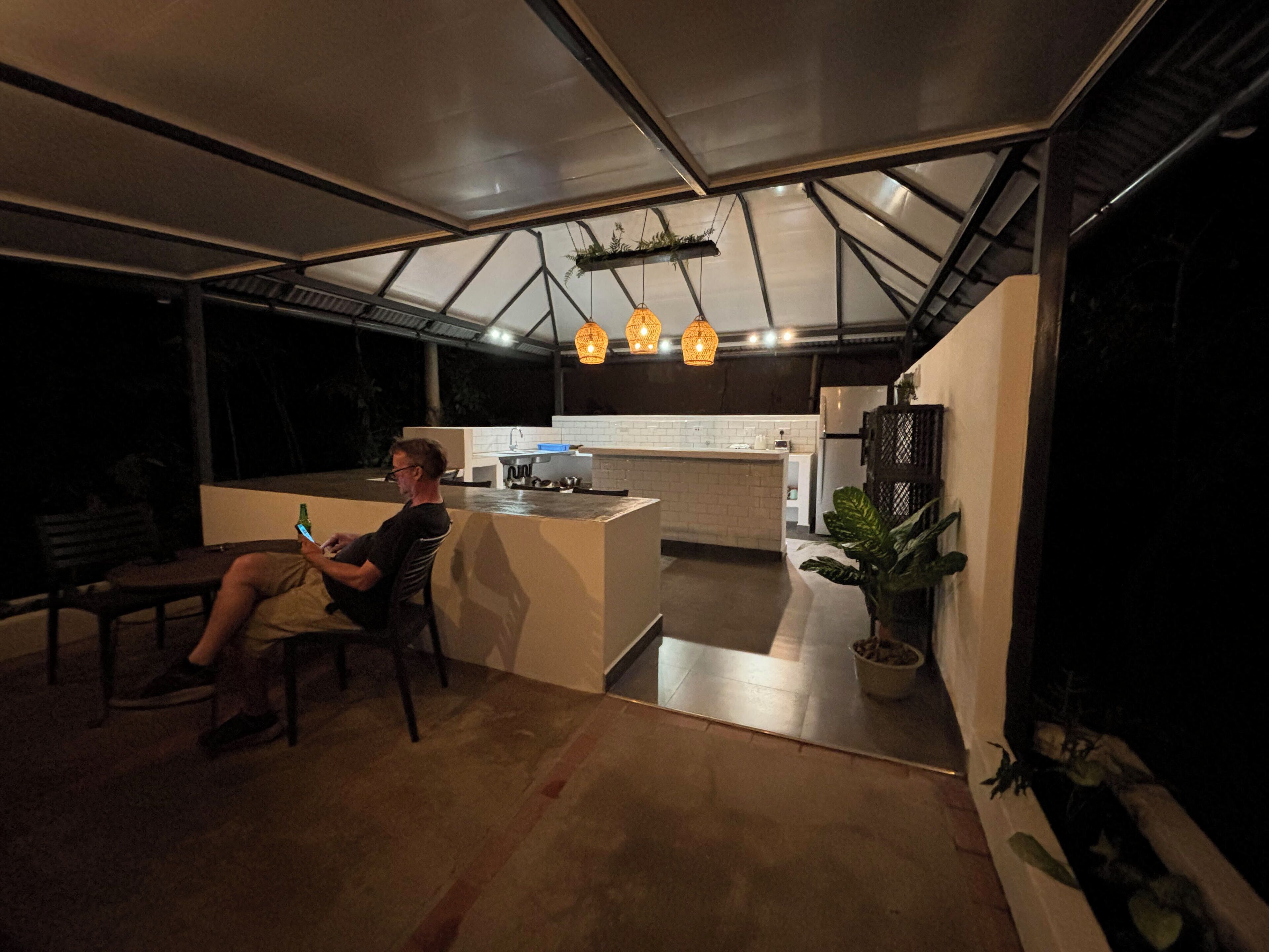 A modern kitchen with a central island, pendant lighting, and a dining area with a bench.