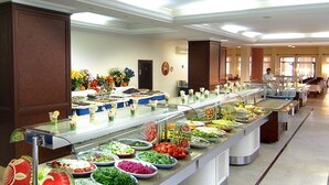 Een buffet met diverse gerechten en een persoon op de achtergrond.
