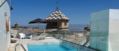 Una piscina al aire libre de temporada, sombrillas