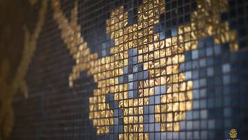Un primer plano de una pared de mosaicos con un diseño dorado.
