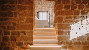 A stone staircase leading to a bedroom with a canopy bed. - Hotel Palacio de Úbeda 5 G.L. (Úbeda)