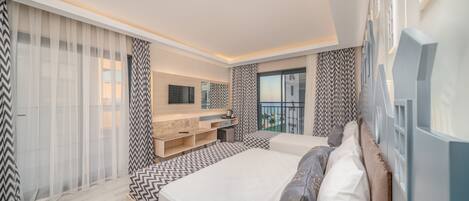 Una camera da letto moderna con un letto grande, TV integrata e un balcone con vista.