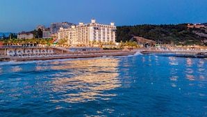 A coastal hotel with multiple balconies, a pier, and a view of the sea. - Aria Resort & Spa (Alanya)