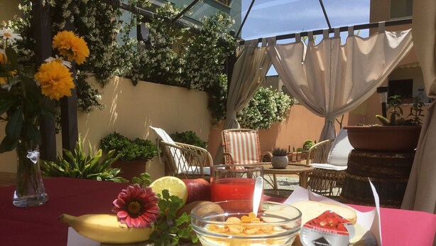 A dining table with a tray of food, including a bowl of cereal, a banana, a lemon, and a glass of juice. - Sun&Sardinia (Monserrato)