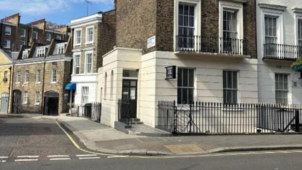 A street view with a row of terraced houses, each with a balcony and a black metal fence. - Golden Star Hotel (London)