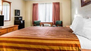 A hotel room with a large bed, a desk with a computer, a chair, and a television. - Golden Star Hotel (London)