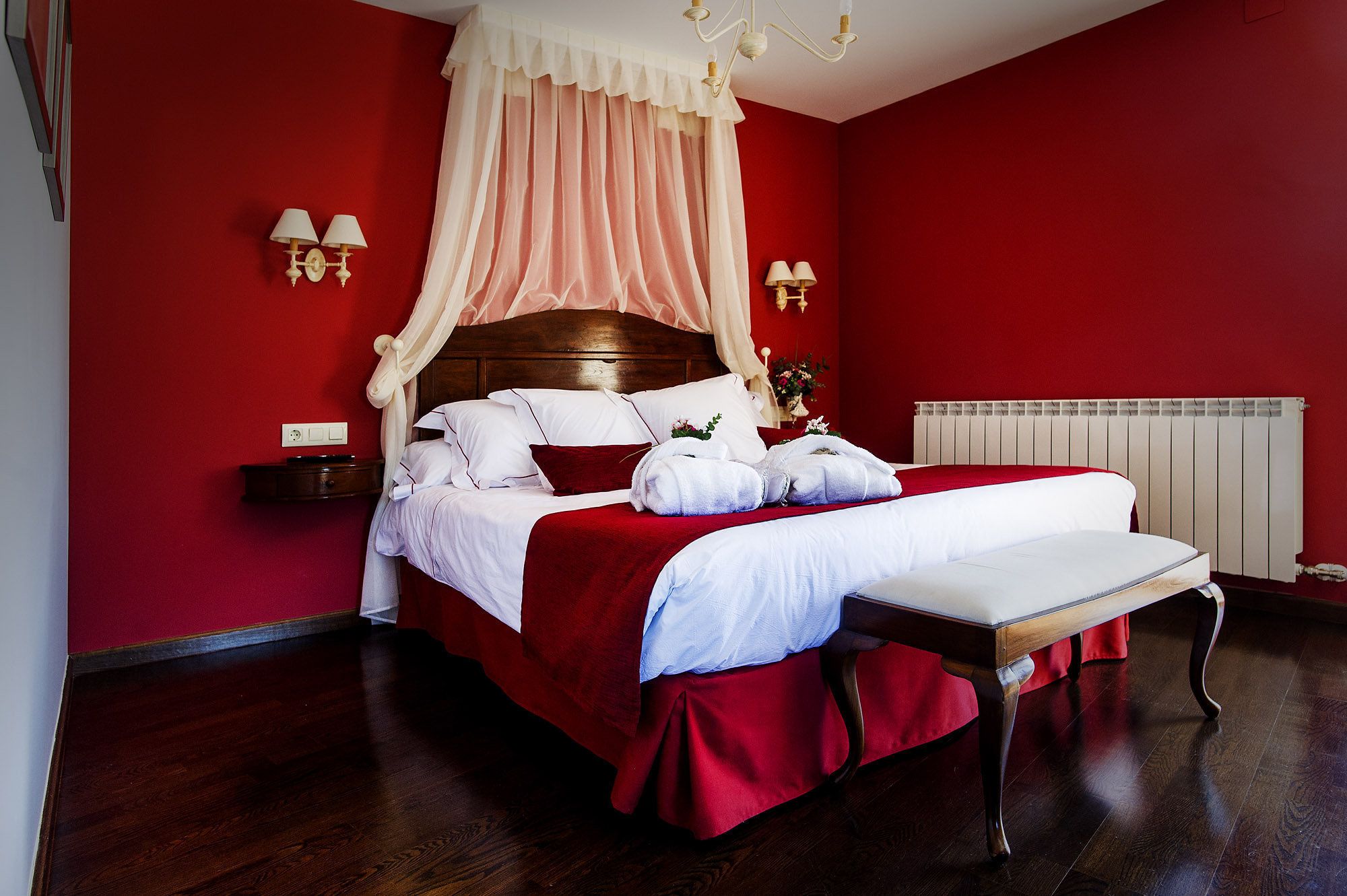 Une chambre à coucher avec un lit à baldaquin, un dais et une table de chevet avec des lampes.